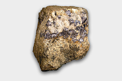 A piece of molybdenite which is dark brow and gold in colour.