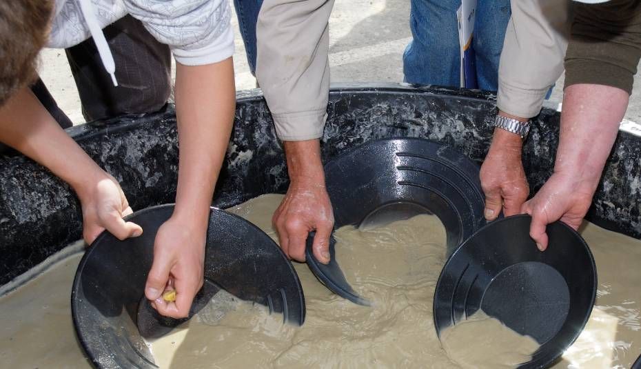 image of people's hands panning in muddy water