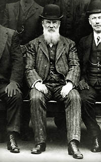 Photo of E J Dunn posing for a photo with a group of men, all wearing suits and hats