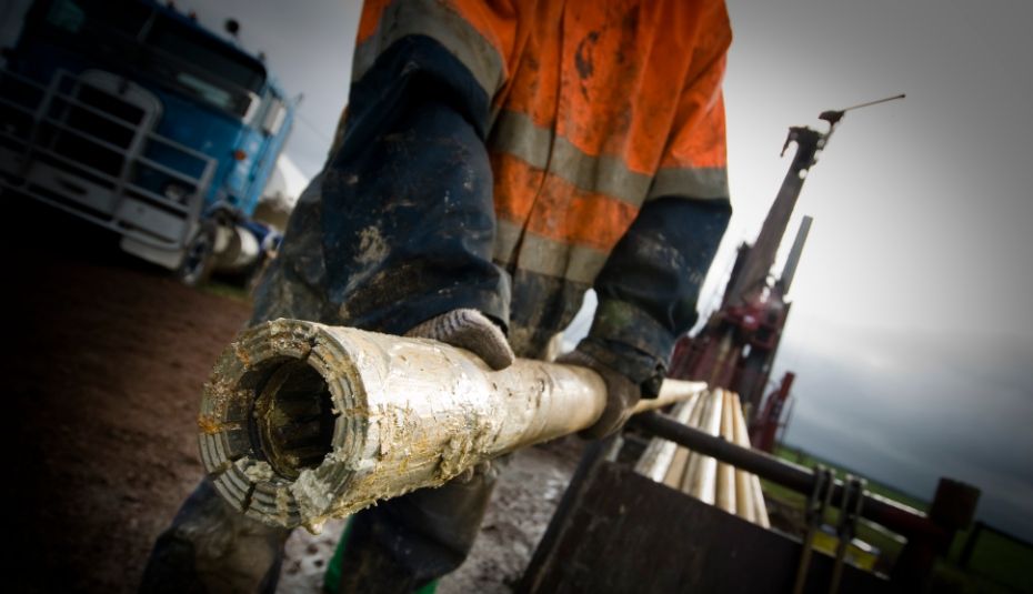 Man in high vis pulling out drill core