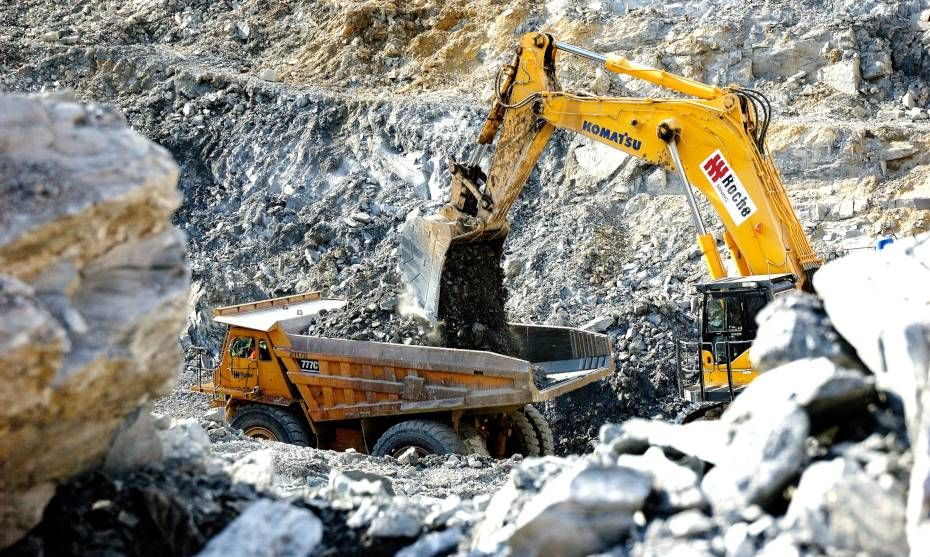 Yellow earth moving trucks driving through quarry