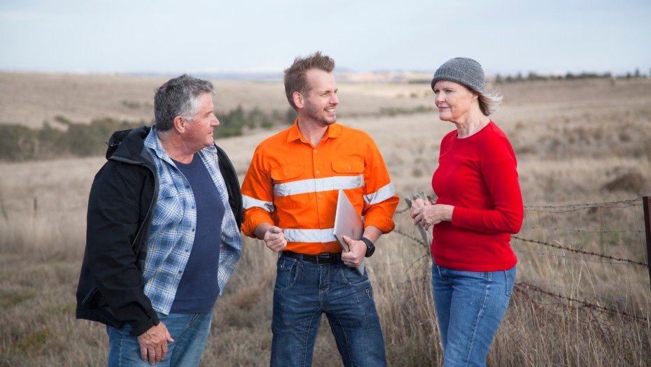 Three people chatting and looking out over a field