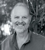A black and white photo of Clive Willman smiling towards camera