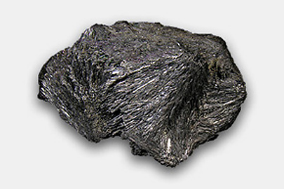 Stibnite from Comadai near Bacchus Marsh, Victoria (Scale: 5 cm) A stibnite – it looks like a black rock with fine grooves on its surface.
